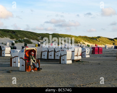 Les personnes âgées assis dans un abri du vent" sur la plage à Norddorf Amrum Allemagne Banque D'Images