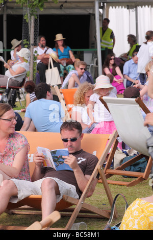 Festival du livre de foin scène mouvementée sur la fête du livre avec les visiteurs de vous détendre sur des chaises longues à lire le programme de l'événement Banque D'Images