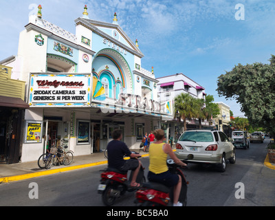 Couple sur cyclomoteur sur Duval Street en passant par le Strand Theatre Banque D'Images