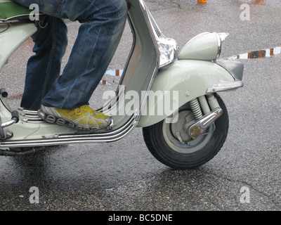 Personne old style vespa lambretta scooter cyclomoteur type dans la pluie à Rome Italie Banque D'Images