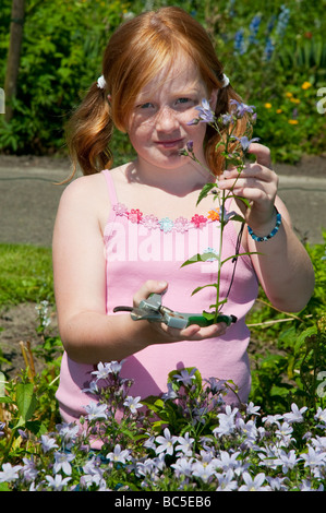 Fille, c'est cueillir des fleurs dans le jardin Banque D'Images