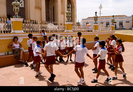 Les enfants de l'école jouant en cercle en ville Place de la vieille ville coloniale de Trinidad à Cuba Banque D'Images