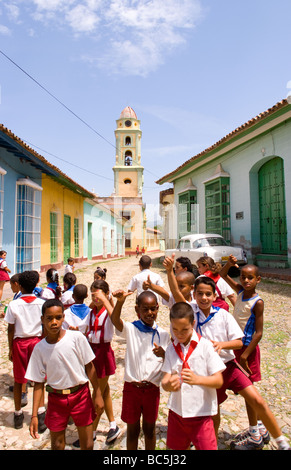 Enfants jouant dans l'école scène cstreet avec ancienne église de l'ancienne ville coloniale de Trinidad à Cuba Banque D'Images