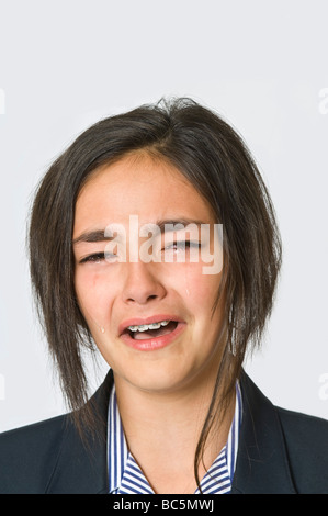 Portarait de la tête et des épaules d'une jeune fille de race blanche (12) pleurer, le port de l'uniforme scolaire. Banque D'Images