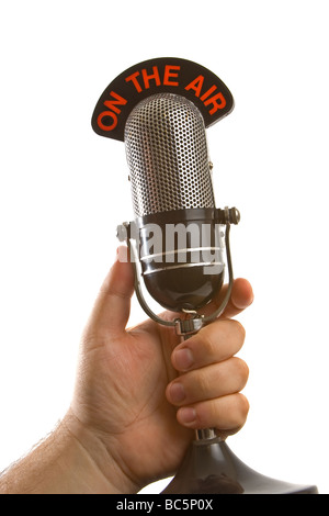 Retro Microphone tenu dans la main sur fond blanc Banque D'Images