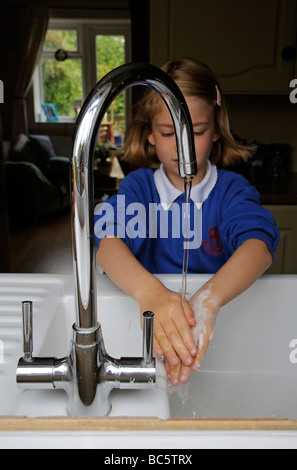 Se laver les mains de l'enfant sous un robinet de cuisine Banque D'Images