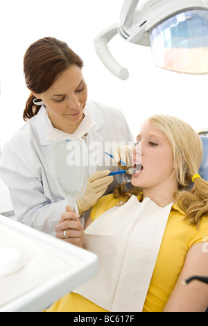 Femme dentiste dents du patient l'examen Banque D'Images