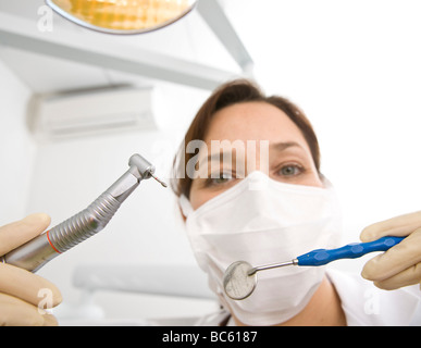 Portrait of female dentist holding fraise dentaire et miroirs inclinable Banque D'Images