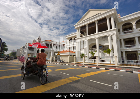 Un trishaw passe l'Édifice de la Cour suprême à Georgetown, Penang, Malaisie. Banque D'Images