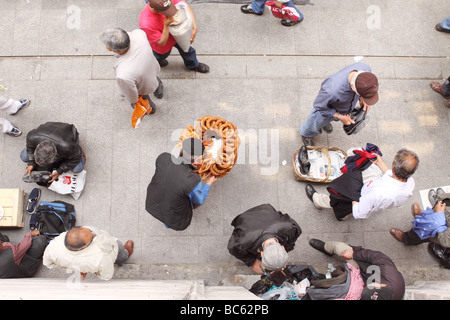 Istanbul Turquie aerial market street scène montrant l'homme Vente de pain simit anneaux couverts de graines de sésame scène de foule animée Banque D'Images