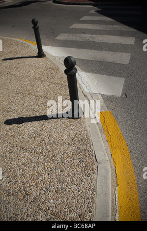 Bittes d'ombres à un franchissement routier sur une route avec des marquages peints en espagnol Banque D'Images