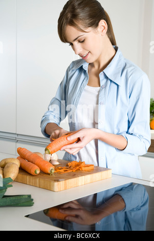 Woman peeling carrot Banque D'Images