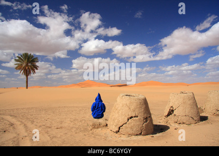 Personne qui porte marocaine djellabah par la boue d'un four à la recherche d'Erg Chebbi dunes de sable, désert du Sahara, Merzouga, Moroccco Banque D'Images