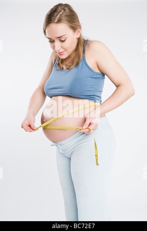 Pregnant woman measuring belly Banque D'Images