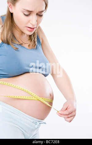 Pregnant woman measuring belly Banque D'Images