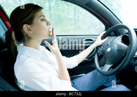 Woman driving car pris par surprise Banque D'Images