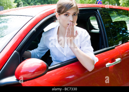 Woman driving car pris par surprise Banque D'Images