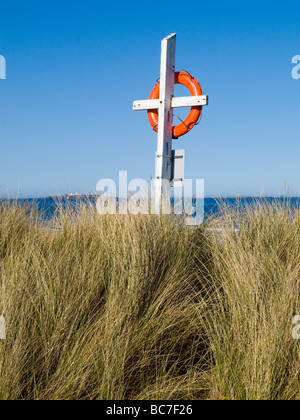 Gros plan d'une bouée de couleur orange vif dans les dunes sur la plage à Largs, sur la magnifique côte de Northumberland England UK Banque D'Images