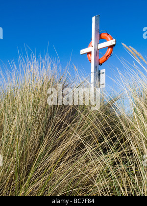 Gros plan d'une bouée de couleur orange vif dans les dunes sur la plage à Largs, sur la magnifique côte de Northumberland England UK Banque D'Images