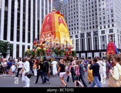 New York City la parade du festival Hindou Hare Krishna haut en couleur flotte sur Fifth Avenue dans Midtown Manhattan. Foule regardant la procession religieuse hindoue. Banque D'Images