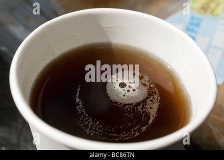 Bulles flottant sur un café noir dans une tasse en polystyrène Banque D'Images