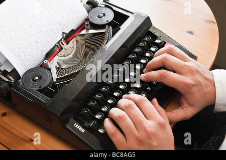 Type de main d'hommes noirs sur machine à écrire. Le texte sur le papier se lit comme suit : "Tous les travaux et pas de jeu fait de Jack un garçon terne.' plus et plus. Banque D'Images
