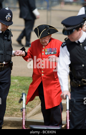 Un frai Chelsea pensionné aidé par des policiers lors de l'Association anciens camarades de cavalerie Parade dans Hyde Park Londres Banque D'Images