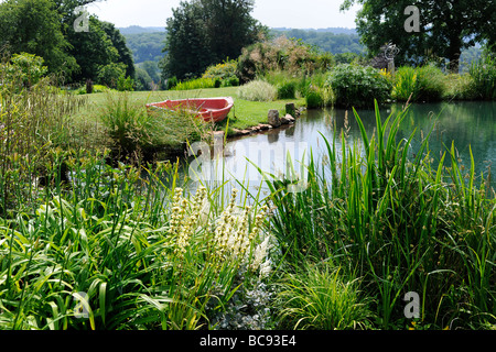 Lac avec rowng bateau dans un jardin anglais aménagé en parc Swan Mews, Somerset, UK Banque D'Images