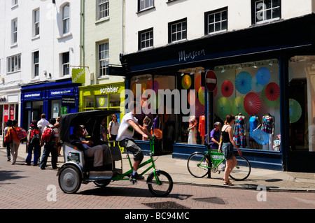 Un pedicab rickshaw vélo transportant les touristes dans la région de Market Street dans le centre-ville de Cambridge en Angleterre, Royaume-Uni Banque D'Images