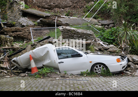 Les conséquences dévastatrices d'un glissement de terrain. Une camionnette blanche écrasés et ensevelis sous des éboulis et de débris. Banque D'Images