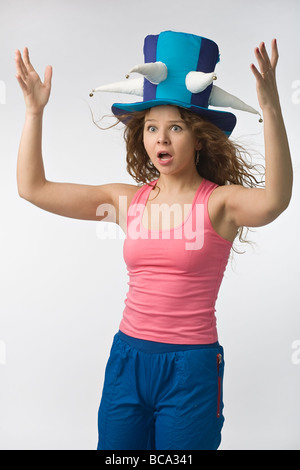 Fille emotionall dans big fan de football hat sur fond gris Banque D'Images