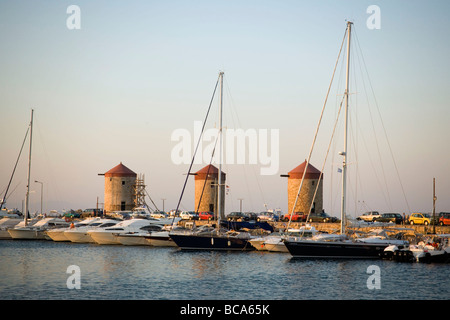 Vue sur le port de Mandraki (traduit littéralement : fois) avec les navires d'ancrage pour les moulins à vent sur la mole, la ville de Rhodes, Rhodes, Grèce Banque D'Images