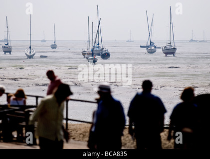 Les humains et les bateaux à marée basse à Leigh on Sea dans l'Essex. Banque D'Images