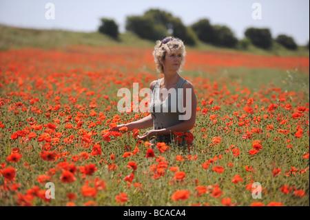 Blonde femme debout dans un champ de coquelicots juste au nord de Brighton à Brighton and Hove dans l'East Sussex Banque D'Images