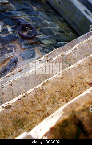 Marches de pierre dans le port anglais traditionnel avec bague de fer rouillé en arrière-plan. Banque D'Images