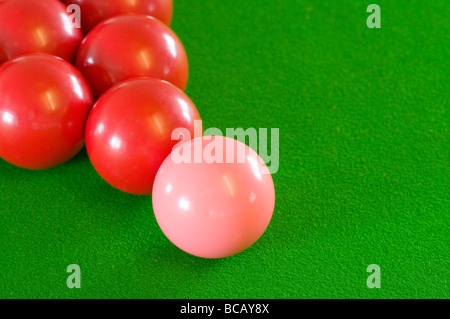 La boule de billard Rose à un triangle de boules rouges sur feutrine verte Banque D'Images