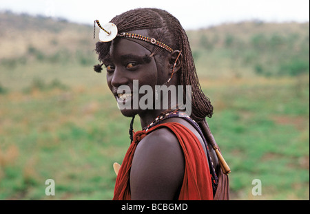 Moran Maasai ou guerrier porte des perles traditionnelles et de longs cheveux de la réserve nationale de Masai Mara au Kenya Afrique de l'Est Banque D'Images