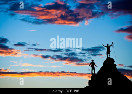 Équipe de grimpeurs qui se profile comme ils clos après avoir atteint le sommet d'un rocher pinnacle dans les montagnes de la Sierra Nevada Cali Banque D'Images