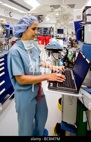 Avant une opération, un chirurgien femme portant des gommages corporels avis voyageurs renseignements médicaux dans un hôpital salle d'opération Orange CA Banque D'Images