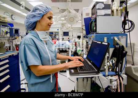 Avant une opération, un chirurgien femme portant des gommages corporels avis voyageurs renseignements médicaux dans un hôpital salle d'opération Orange CA Banque D'Images