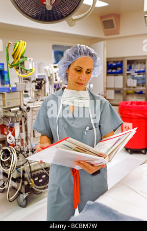 Avant une opération, un chirurgien femme portant des gommages corporels avis voyageurs renseignements médicaux dans un hôpital salle d'opération Orange CA Banque D'Images