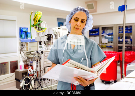 Avant une opération, un chirurgien femme portant des gommages corporels avis voyageurs renseignements médicaux dans un hôpital salle d'opération Orange CA Banque D'Images