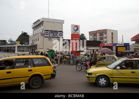 Scène de rue animée avec les taxis d'autres types de trafic et les piétons quartier Deïdo Douala Cameroun Afrique de l'Ouest Banque D'Images