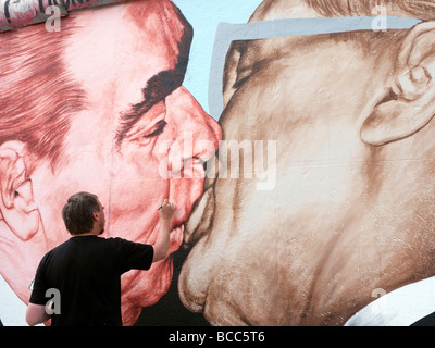 Artiste russe Dimitry Vrubel repeindre sa fameuse fresque originale de Brejnev embrassant Honecker juin sur le mur de Berlin Banque D'Images