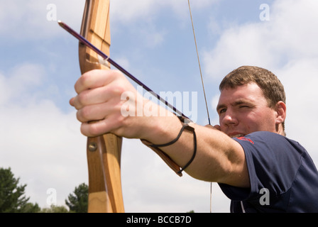 21 ans, homme, et d'essayer au tir à une foire d'été à Blackmoor près de Bordon, Hampshire, Royaume-Uni. Banque D'Images