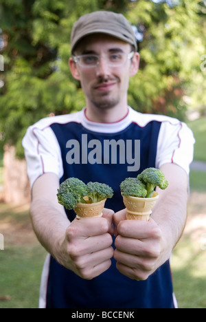 L'homme avec le brocoli rempli des cornets de crème glacée, se concentrer sur des cônes Banque D'Images