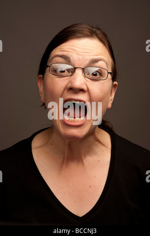 Une femme de trente ans portant des lunettes crier hurler crier faire grand bruit à la féroce en colère furieux Banque D'Images