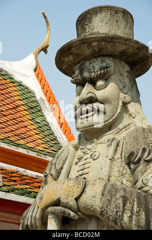 Une énorme statue de pierre représentant une bande dessinée de l'ouest portant sur le bord tolère une grande plage de Wat Pho temple du Bouddha couché à Bangkok Banque D'Images