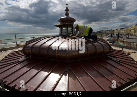 Un ouvrier martelant une nouvelle toiture en cuivre sur un kiosque victorien sur le front de mer de Brighton et Hove Banque D'Images