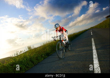 Une femme cycliste route sur la route côtière de Cornwall Banque D'Images